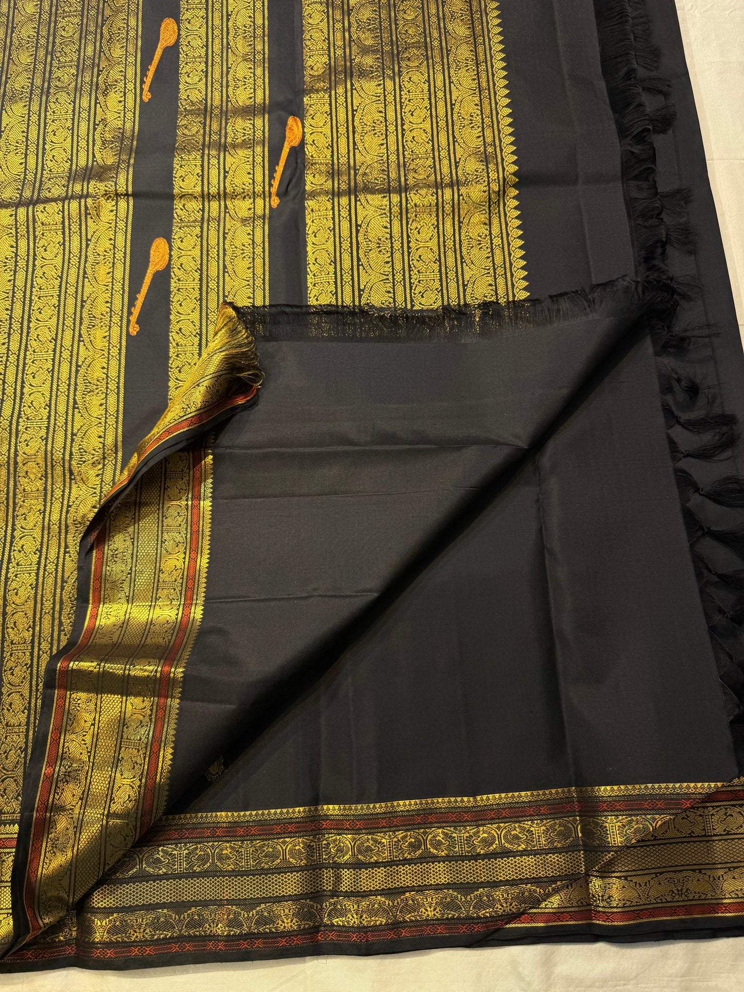 Deepest Kanchana black Kanjivaram silk saree with traditional gold zari and woven motifs.