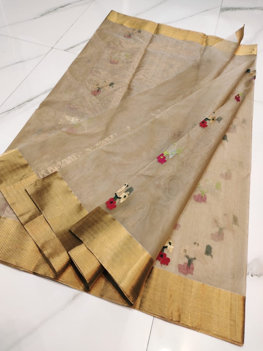 Detail of the champagne beige Chanderi body with scattered multicolour floral buttas and gold border edge