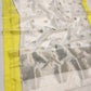 Close view of the ivory Chanderi body with grey floral-bud buttas and the lemon-yellow edge