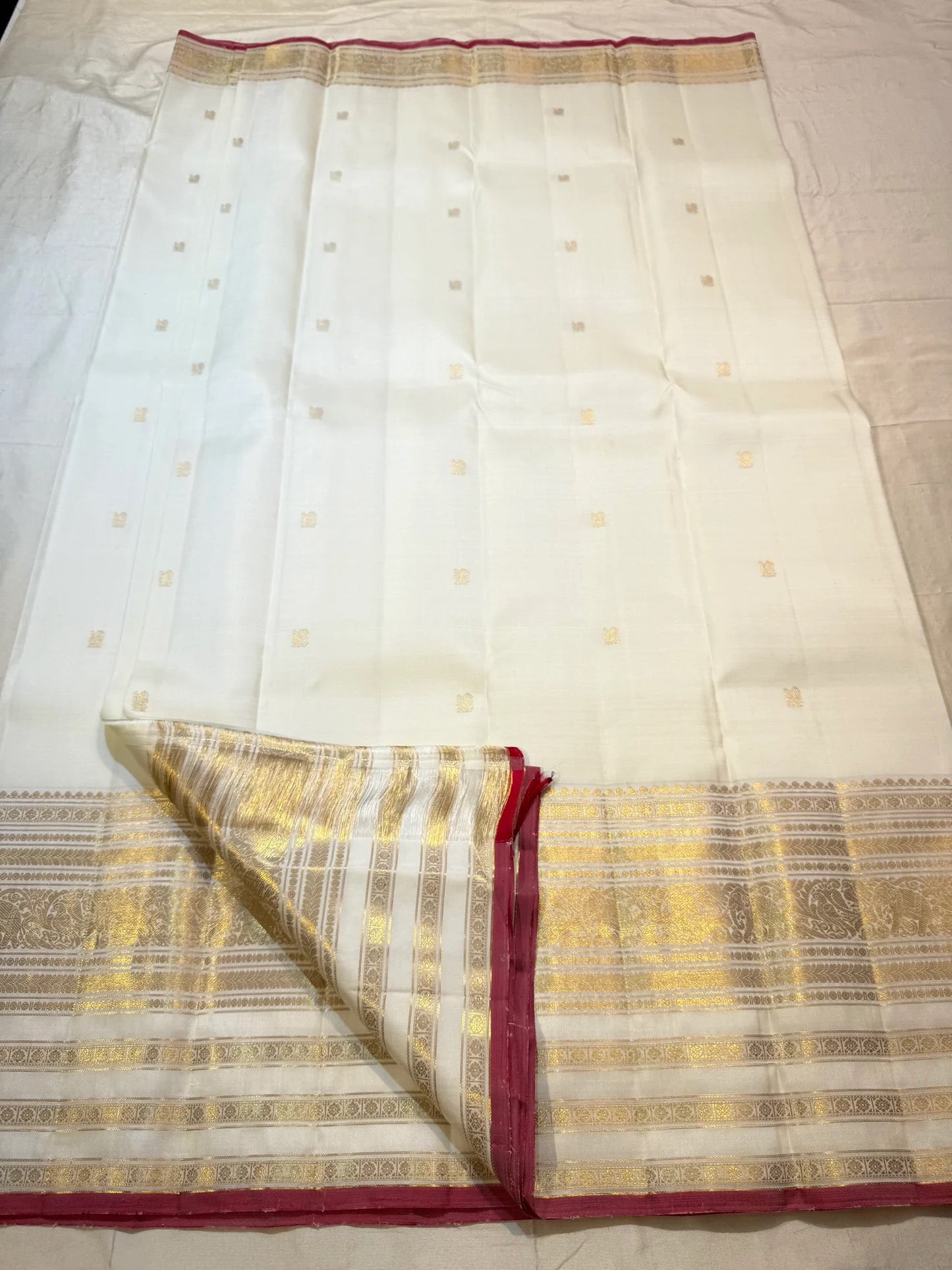 Delicate zari-woven buttas on ivory pure silk Kanchipuram saree body