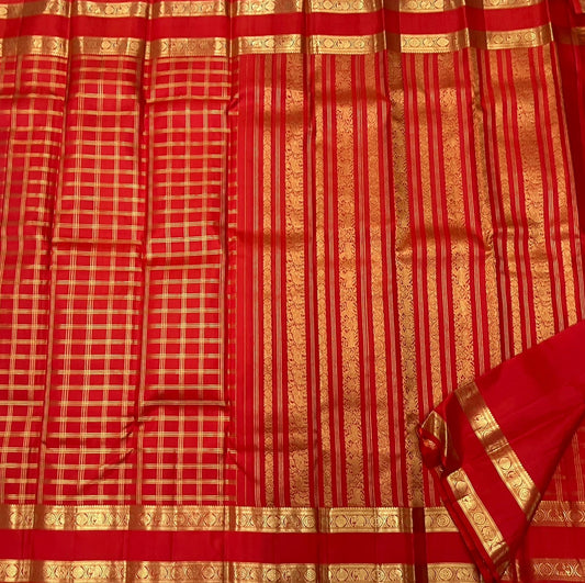 Close view of red Kanchipuram silk saree featuring classic gold zari kattam pattern and structured border