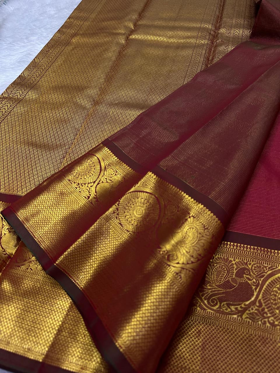 Close view of petite Gandaberunda zari buttas on the red silk body.