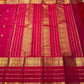Ruby pink Kancheepuram silk saree with traditional zari detailing.