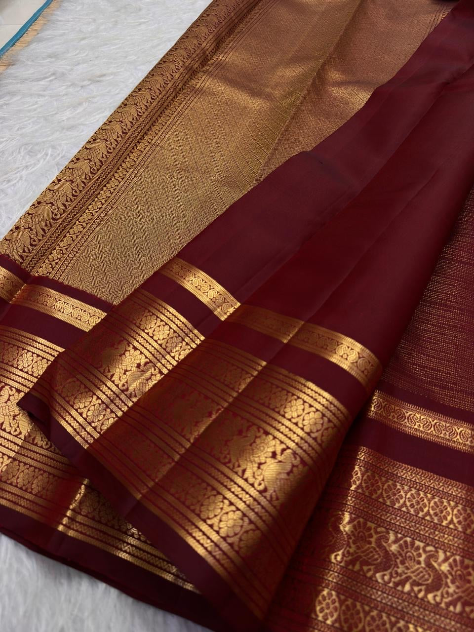 Warm arakku red Kanchipuram zari kattam saree, showing body, border and detailed gold zari pallu