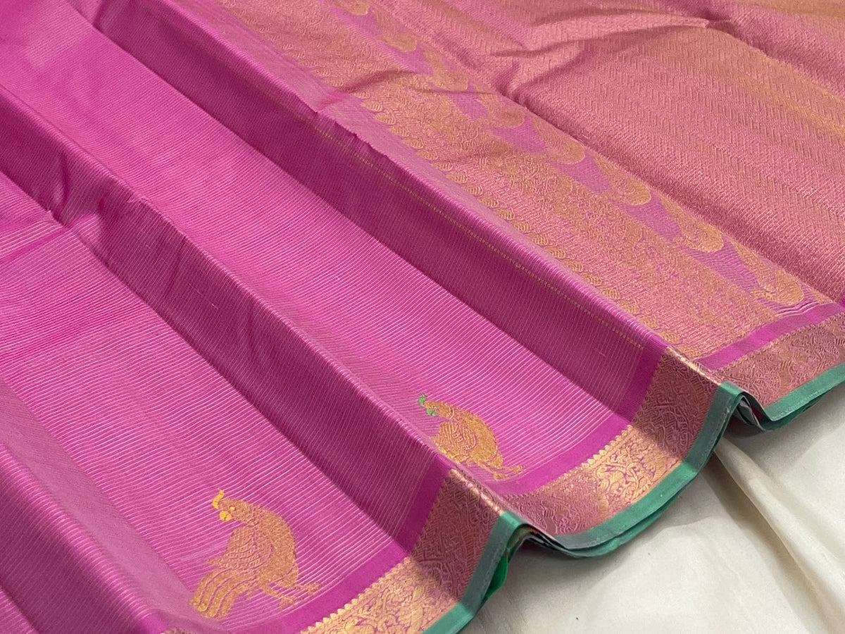 Mint green selvedge and pale gold zari border on an orchid pink Vairaoosi Kanchipuram saree