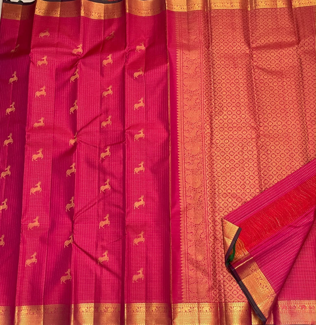 Traditional gold zari pallu on a deep pink magenta Kanjivaram silk saree