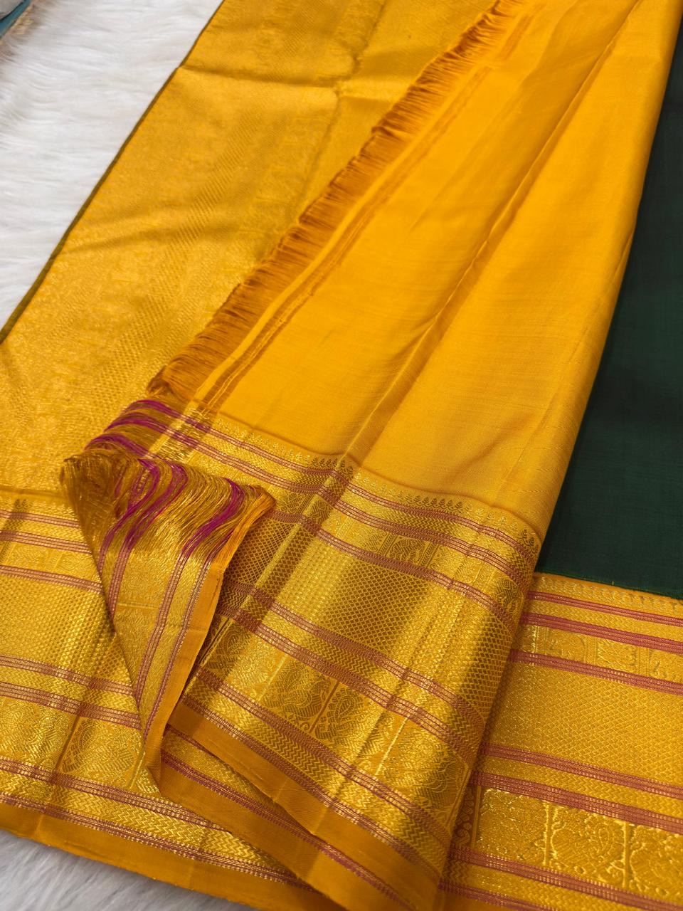 Repeated gold zari and silk-thread bands within the vivid yellow contrast border