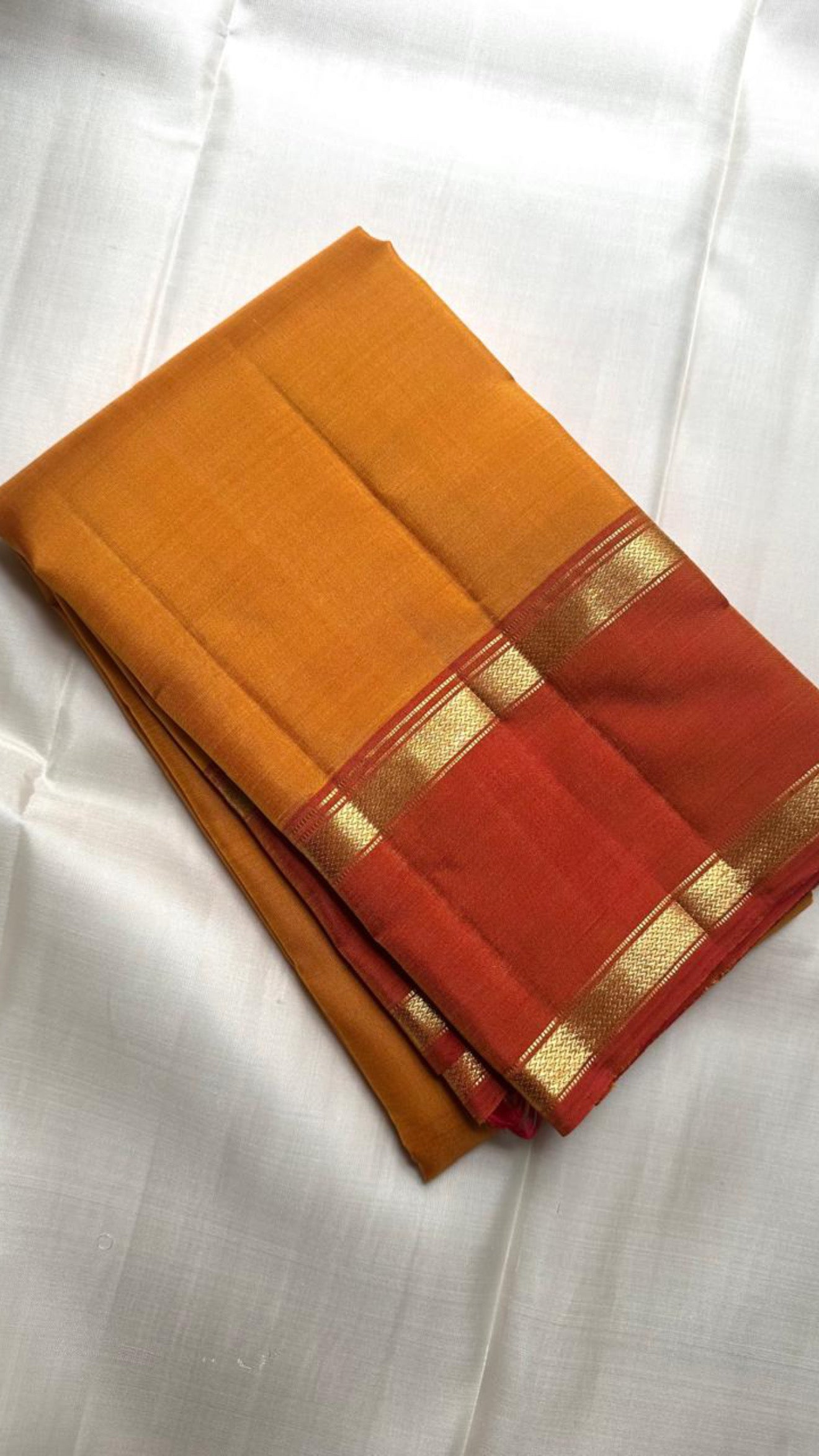 Turmeric gold Kanchipuram silk saree draped, showing Rettapet border and pallu