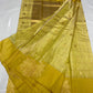 Mustard yellow handloom Chanderi saree draped to show luminous tissue body, gold pallu and large woven border motifs