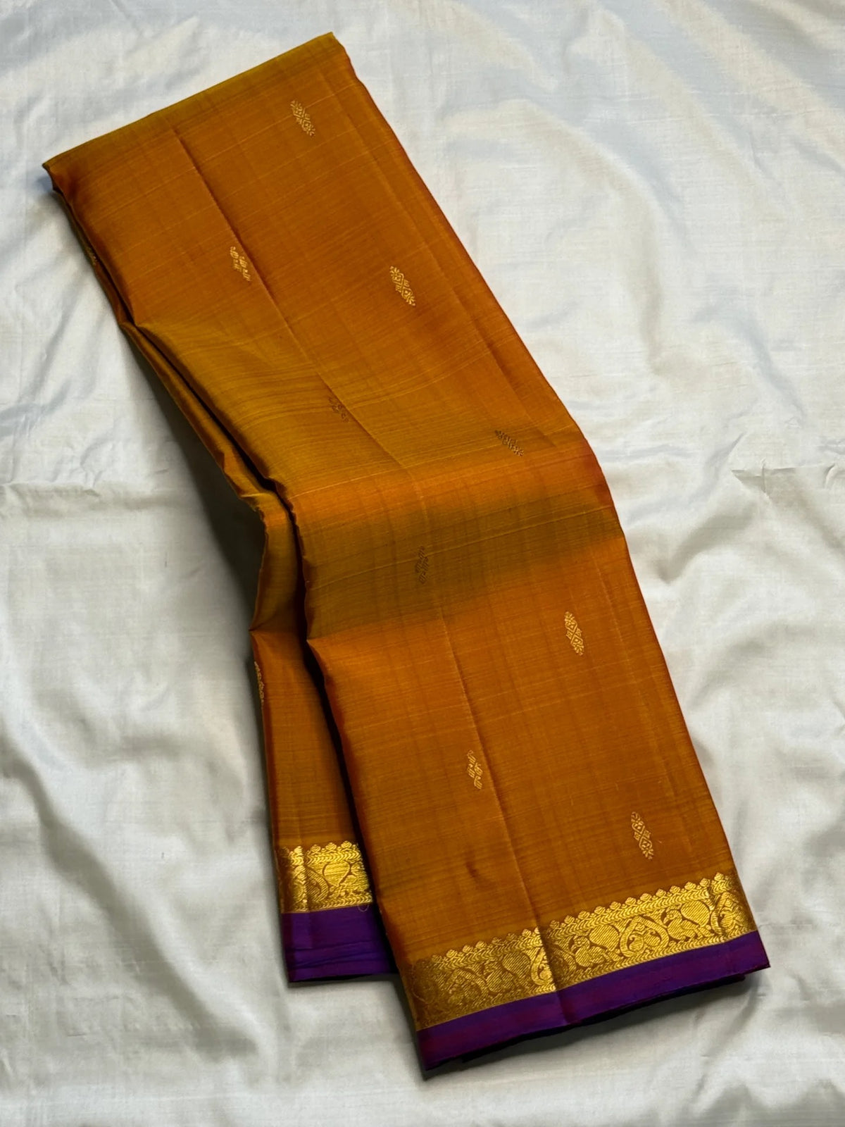 Close view of antique-gold zari motifs woven on Ponvandu Turmeric Yellow Kanjivaram silk.