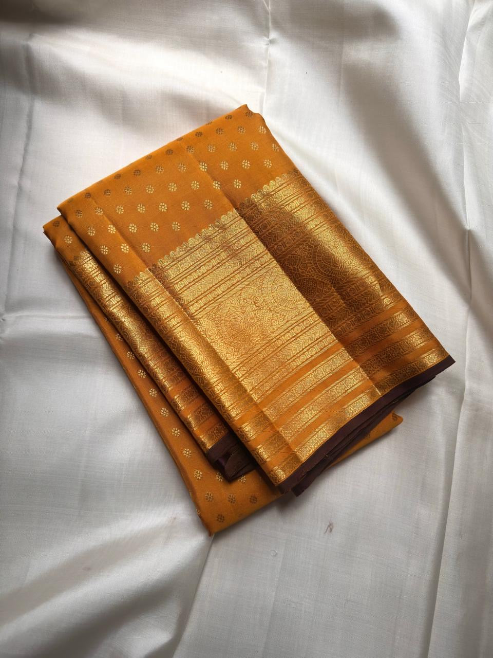 Turmeric Yellow pure silk Kanchipuram saree with antique-gold woven detailing.