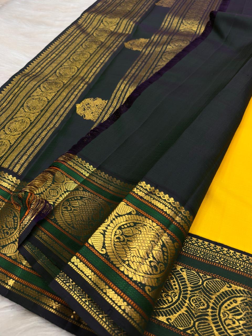 Deep green Kanchipuram border with large paired Mayil peacock medallions in gold zari.