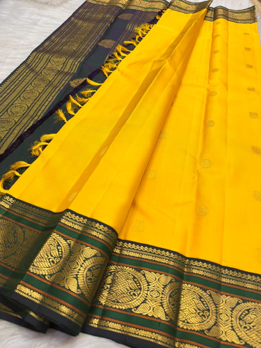 Turmeric Yellow pure silk KanchiPattu Butta saree with deep green double-peacock zari border.