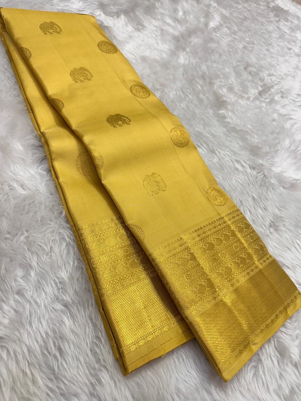 Turmeric yellow Pure Silk Kanchipuram saree with multi-layer Kamalam buttas and broad gold zari border.
