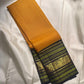 Turmeric yellow Kanjeevaram silk saree with deep navy Varisaipet border, full view