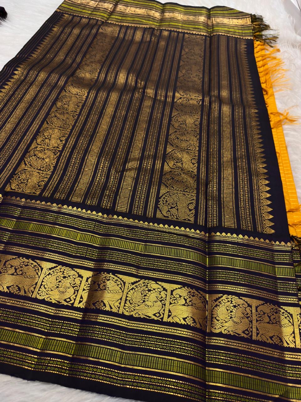 Turmeric yellow Kanjeevaram silk saree with deep navy Varisaipet border, full view