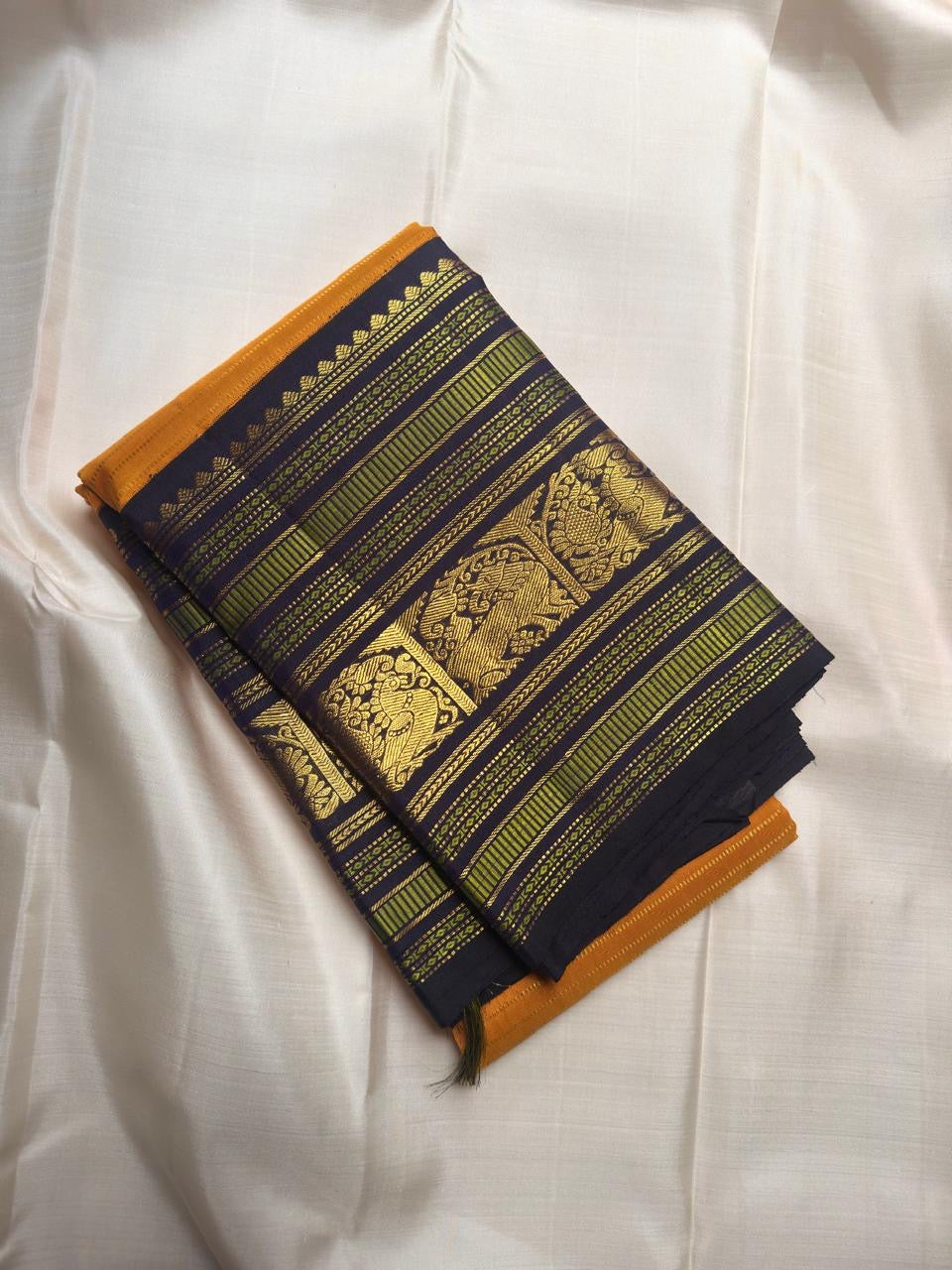 Turmeric yellow Kanjeevaram silk saree with deep navy zari pallu