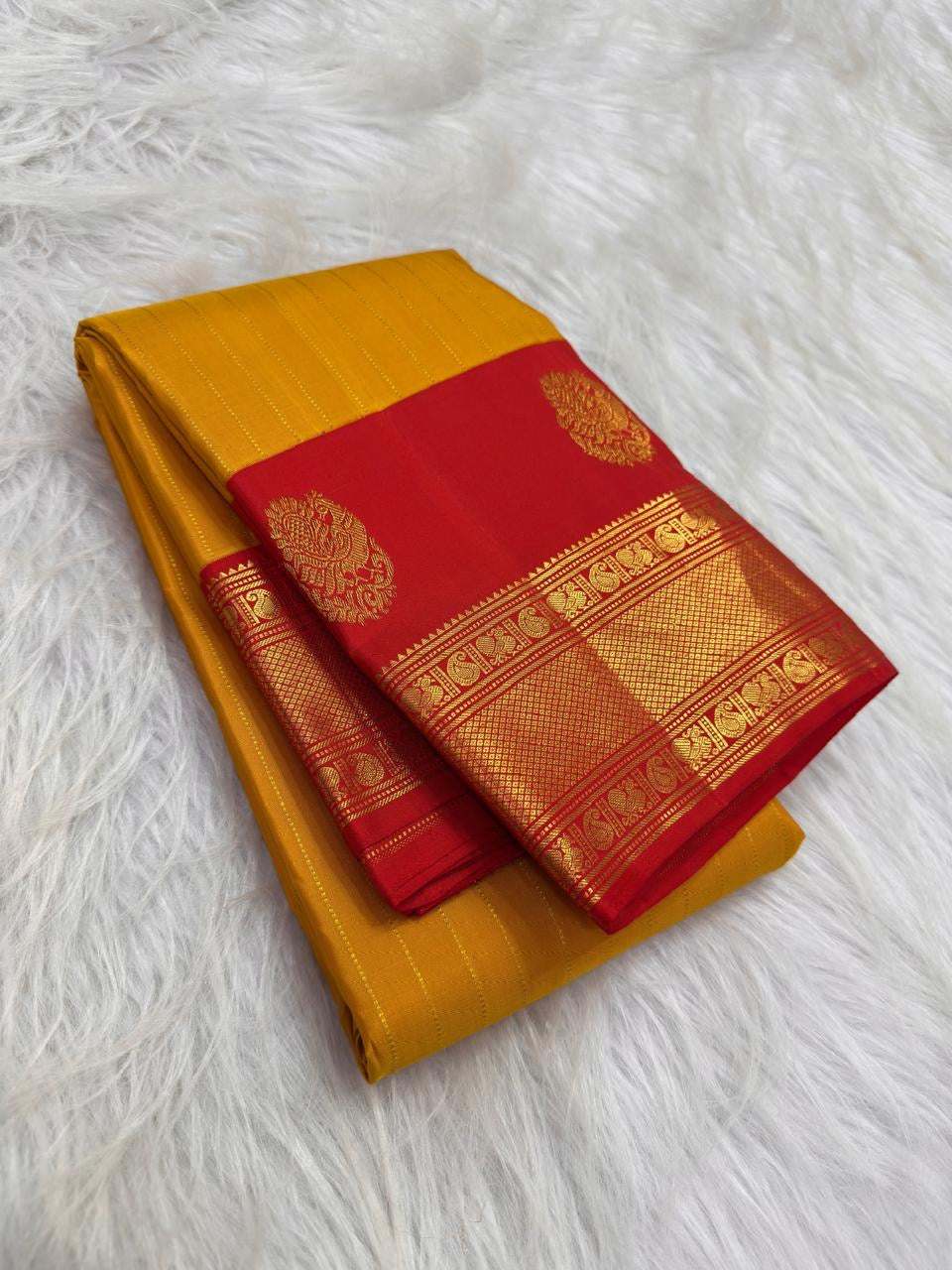 Turmeric Yellow Pure Silk Kanchipuram Butta saree with fine vertical zari lines.