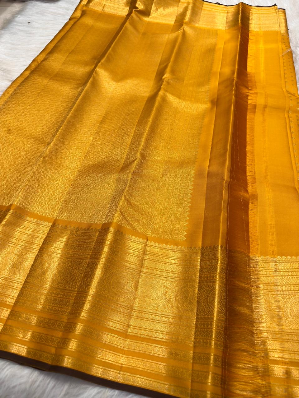Traditional Turmeric Yellow Kanjivaram Butta saree with richly woven pallu.