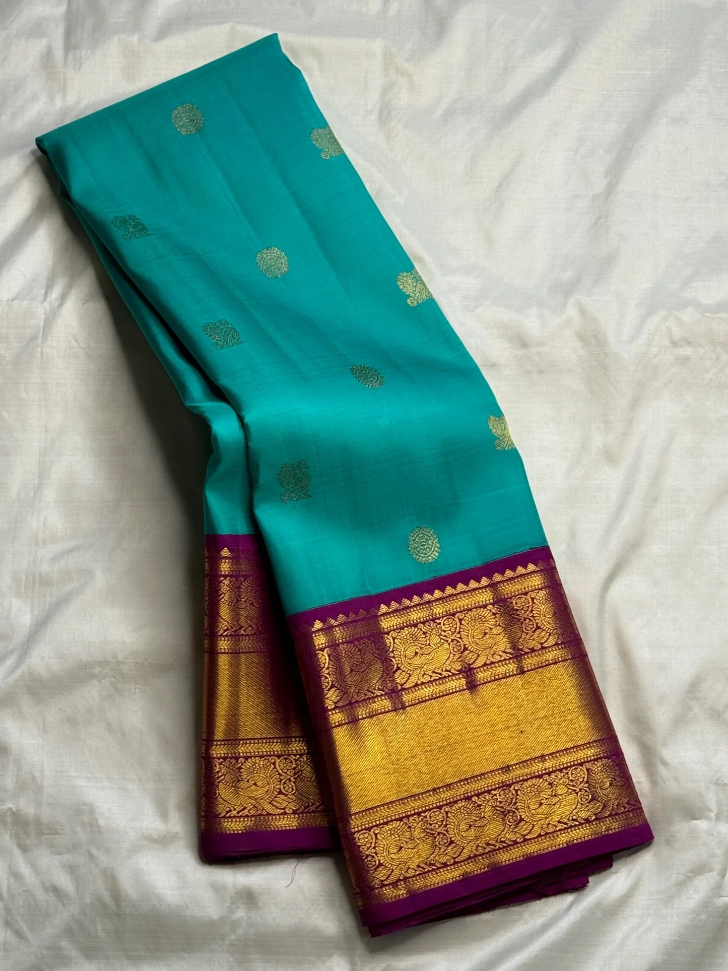 Turquoise Blue Pure Silk Kanchipuram Korvai saree with scattered gold zari buttas and Deep Purple ornamental zari border.