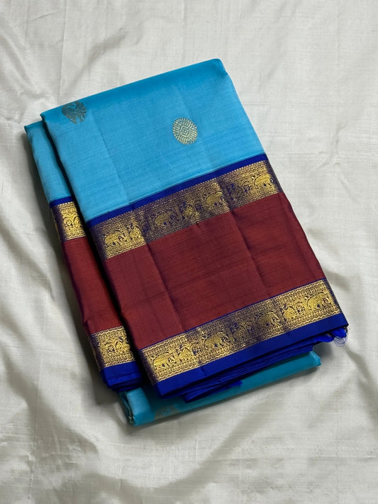 Close-up of Aadum Mayil and Chakram zari buttas on turquoise blue Kanjipuram silk saree