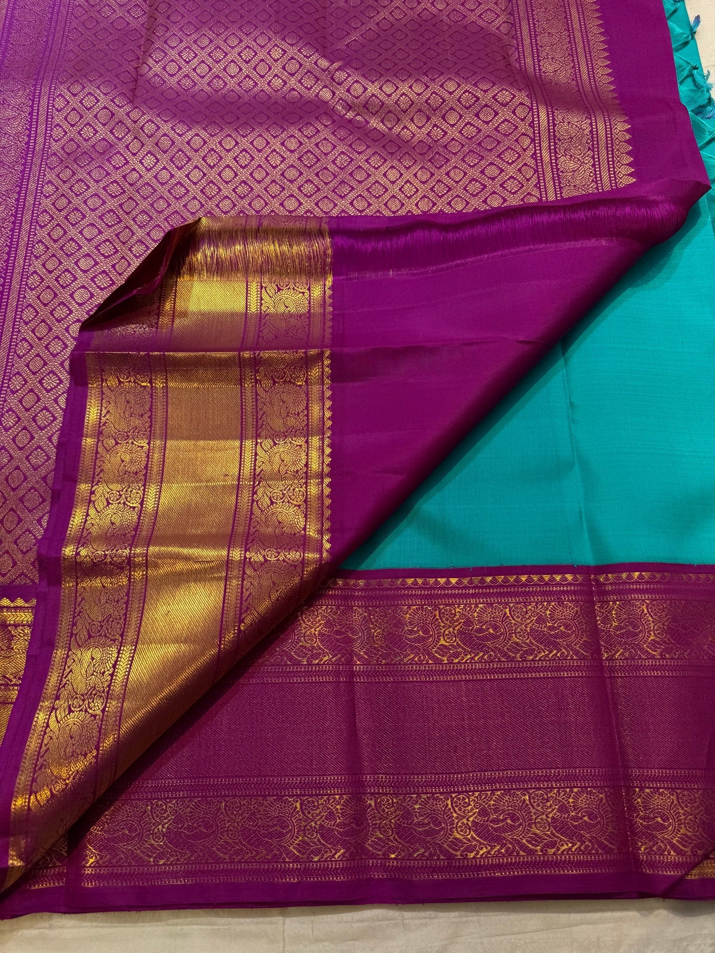 Close view of Deep Purple Kanchipuram Korvai pallu with dense gold zari diamond lattice and Turquoise Blue silk body.