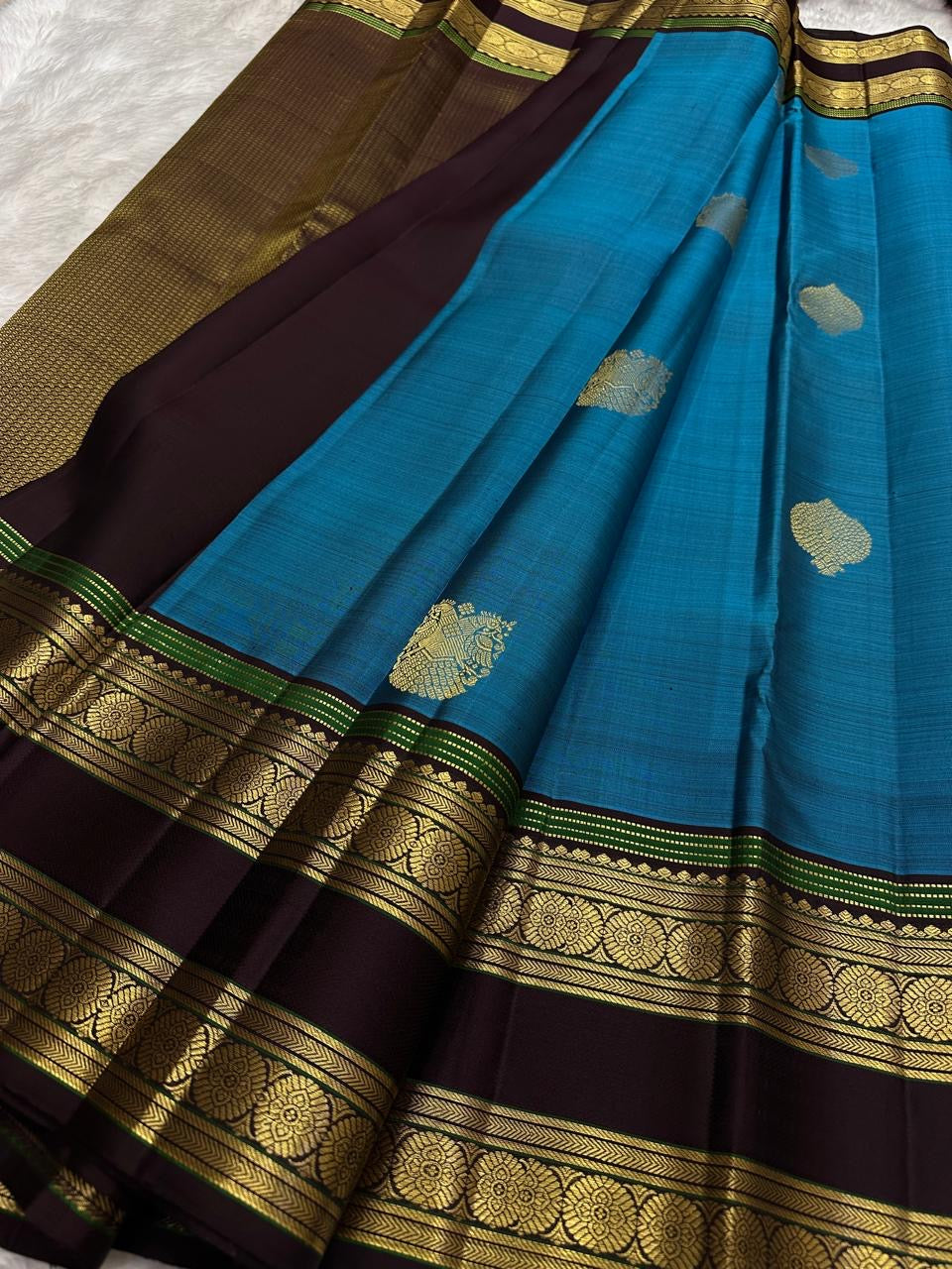 Border detail showing slim green highlight bands and gold zari.