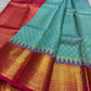 Fuchsia pink pallu on the turquoise blue Kanchipuram saree.