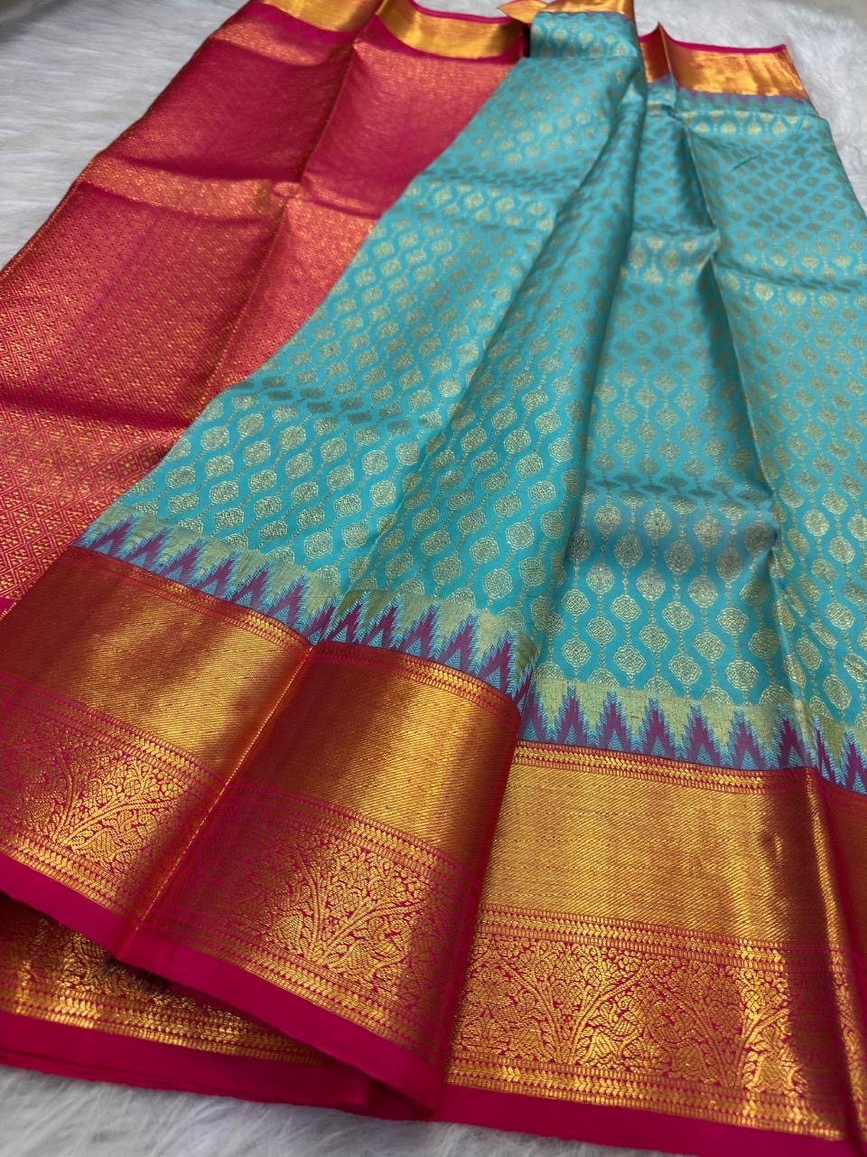 Fuchsia pink pallu on the turquoise blue Kanchipuram saree.
