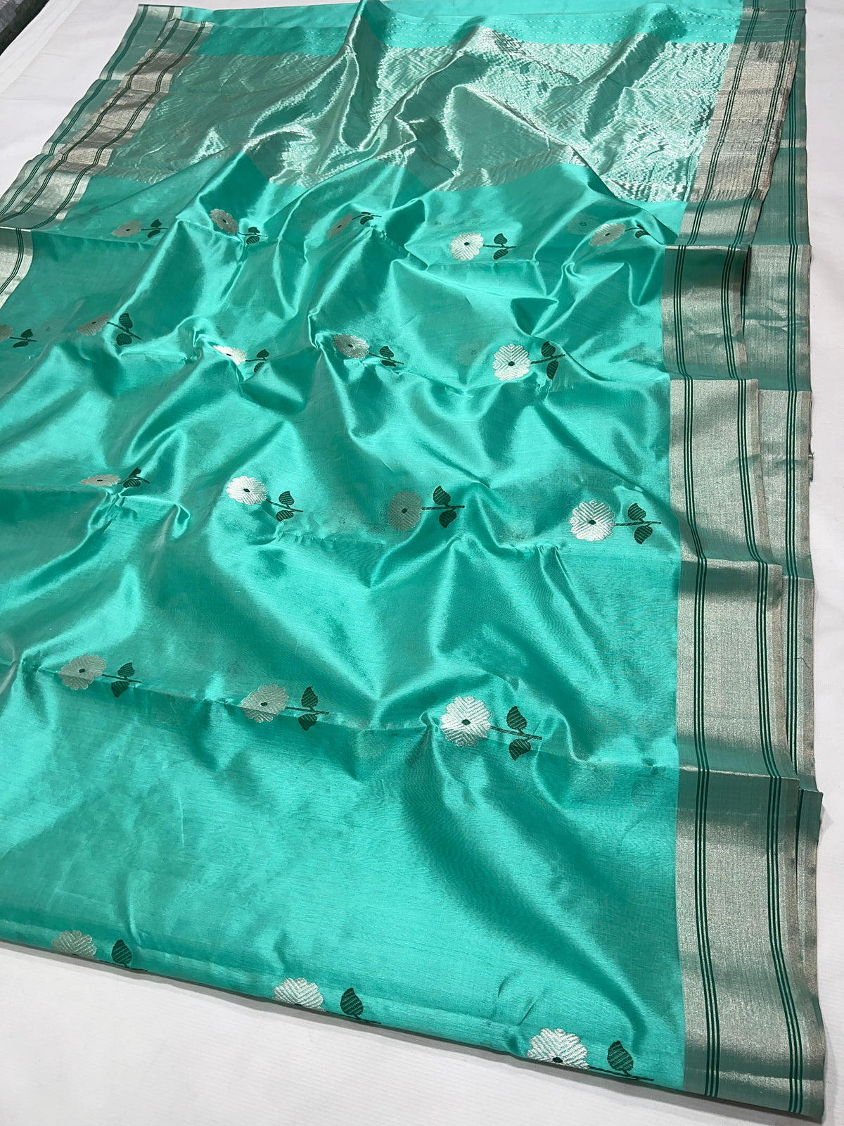 Aqua Turquoise handloom Pattu Silk Chanderi saree with silver floral buttas and deep green leaf accents