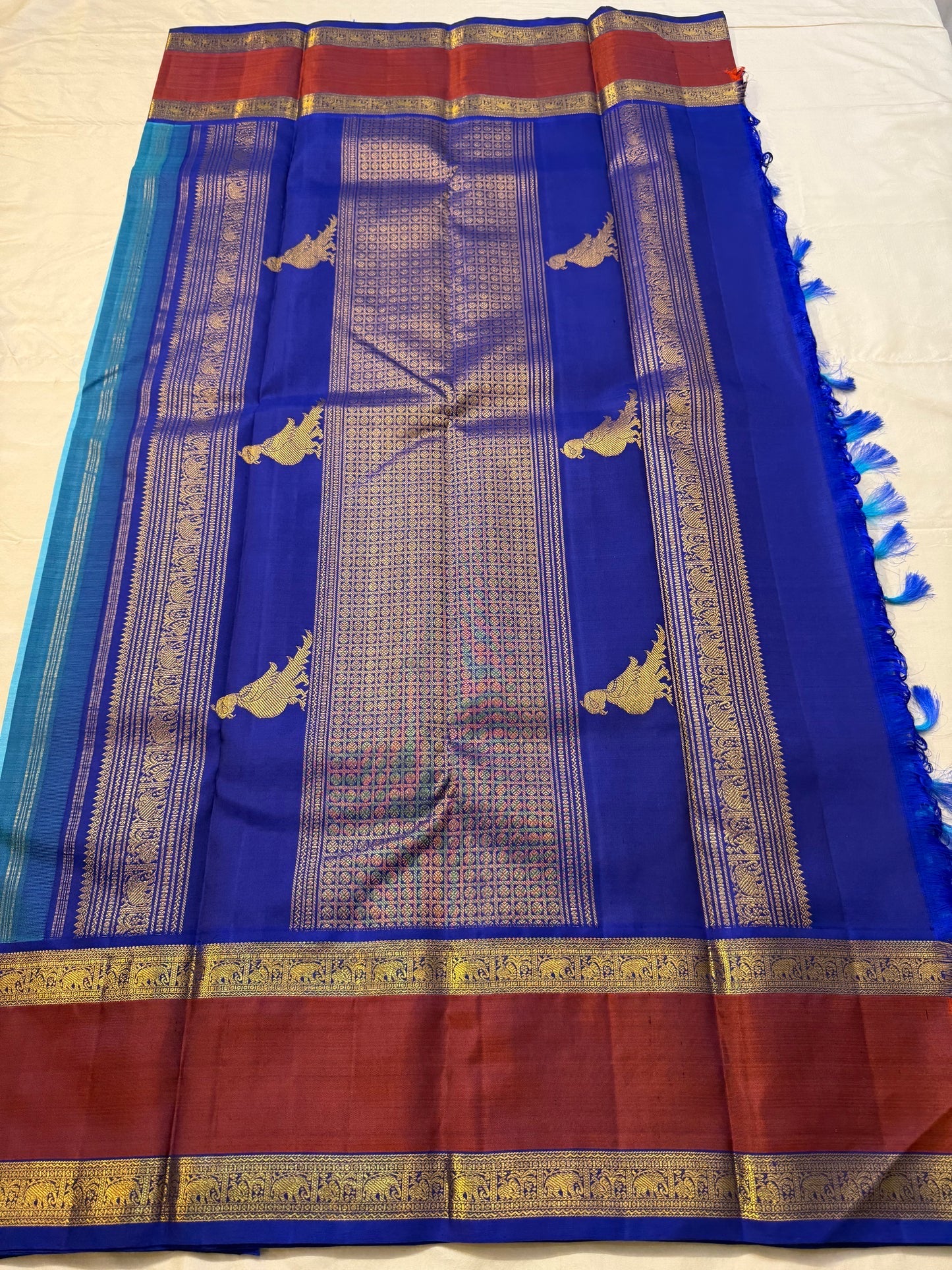 Turquoise blue Kanjipuram Rettapet silk saree folded, showing brick-red border