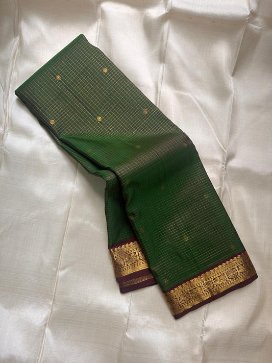 Draped Pure Kanchipuram Silk Saree showing deep green checked body with gold buttas and maroon zari border along the edge.