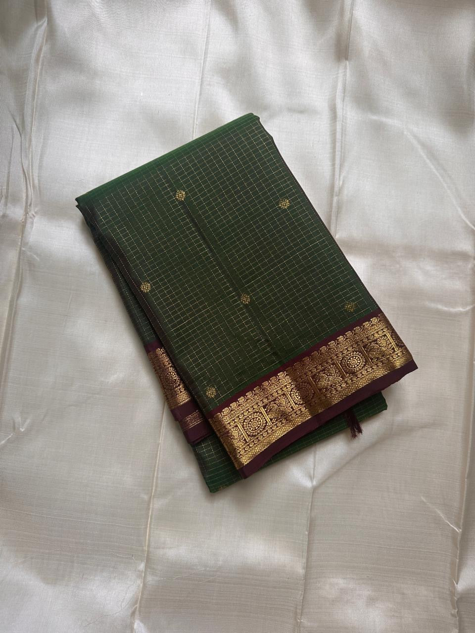 Folded Pure Kanchipuram Silk Saree in deep green checks with small gold buttas and a maroon gold zari border.