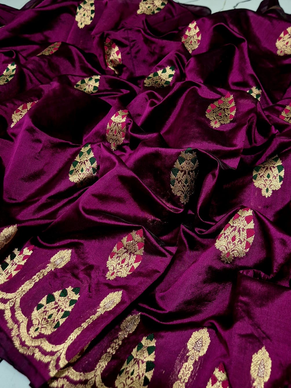 Draped purple handloom Chanderi silk saree with green magenta woven accents and gold-toned border