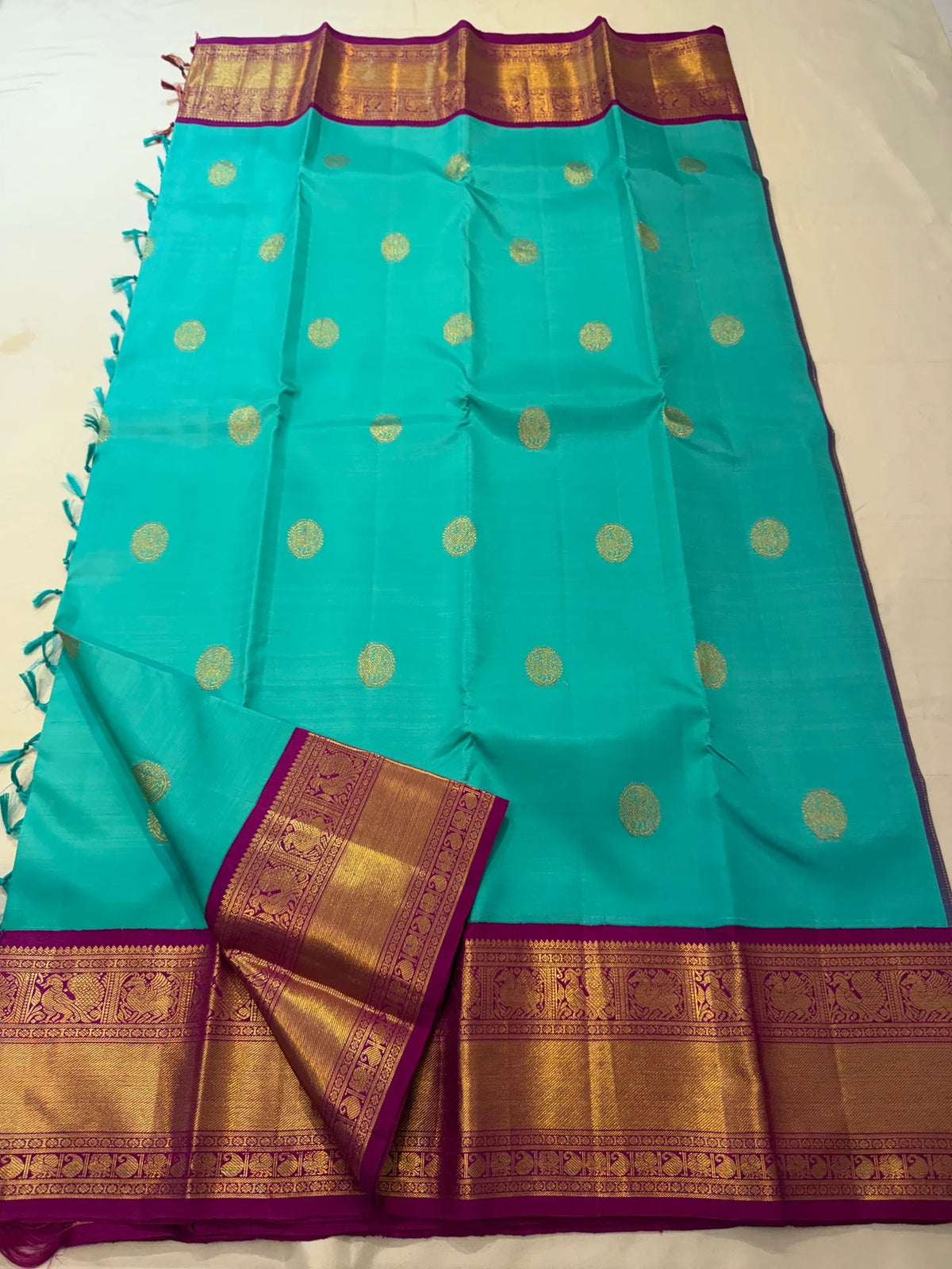 Broad teal blue-green border with dense gold zari, geometric details and stylised bird motifs