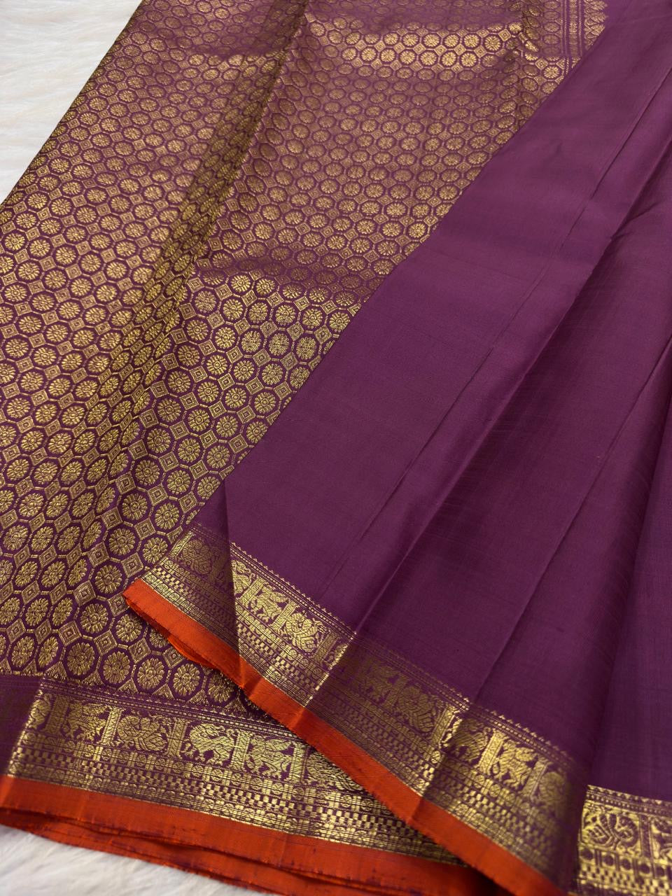 Traditional elephant motif border in antique gold on Vadamalli Purple Kanjivaram saree.
