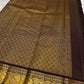 Deep brown Kancheepuram silk saree folded showing Vairaoosi body with Kamalam butta and ornate self-colour Mayil gold zari border