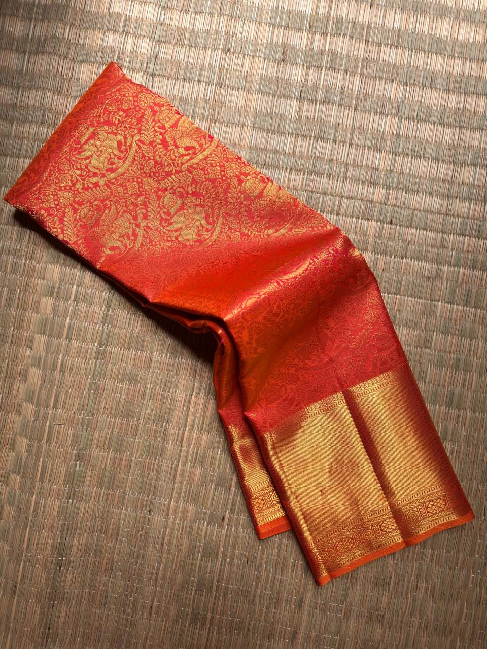 Folded view showing the dense flying horse and floral zari composition against the red silk.