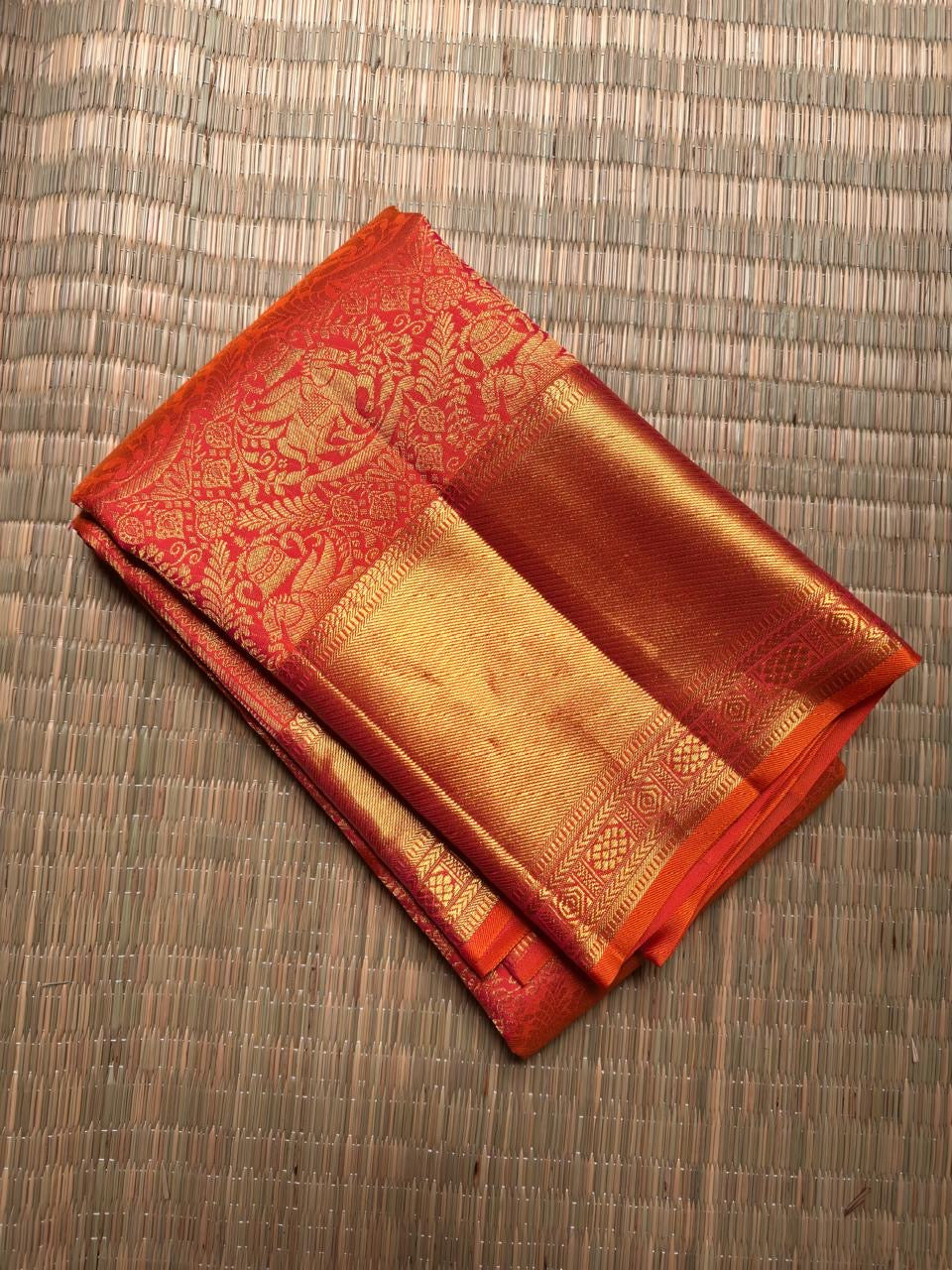 Broad lustrous gold zari border against the Vermilion Coral Red pure silk body.