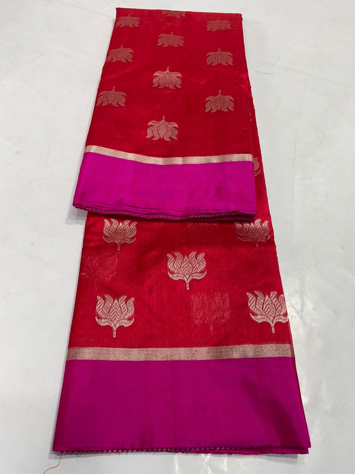 Draped Vermilion Red Chanderi saree showing gold floral buttas, vivid Rani Pink border and fine striped metallic pallu.