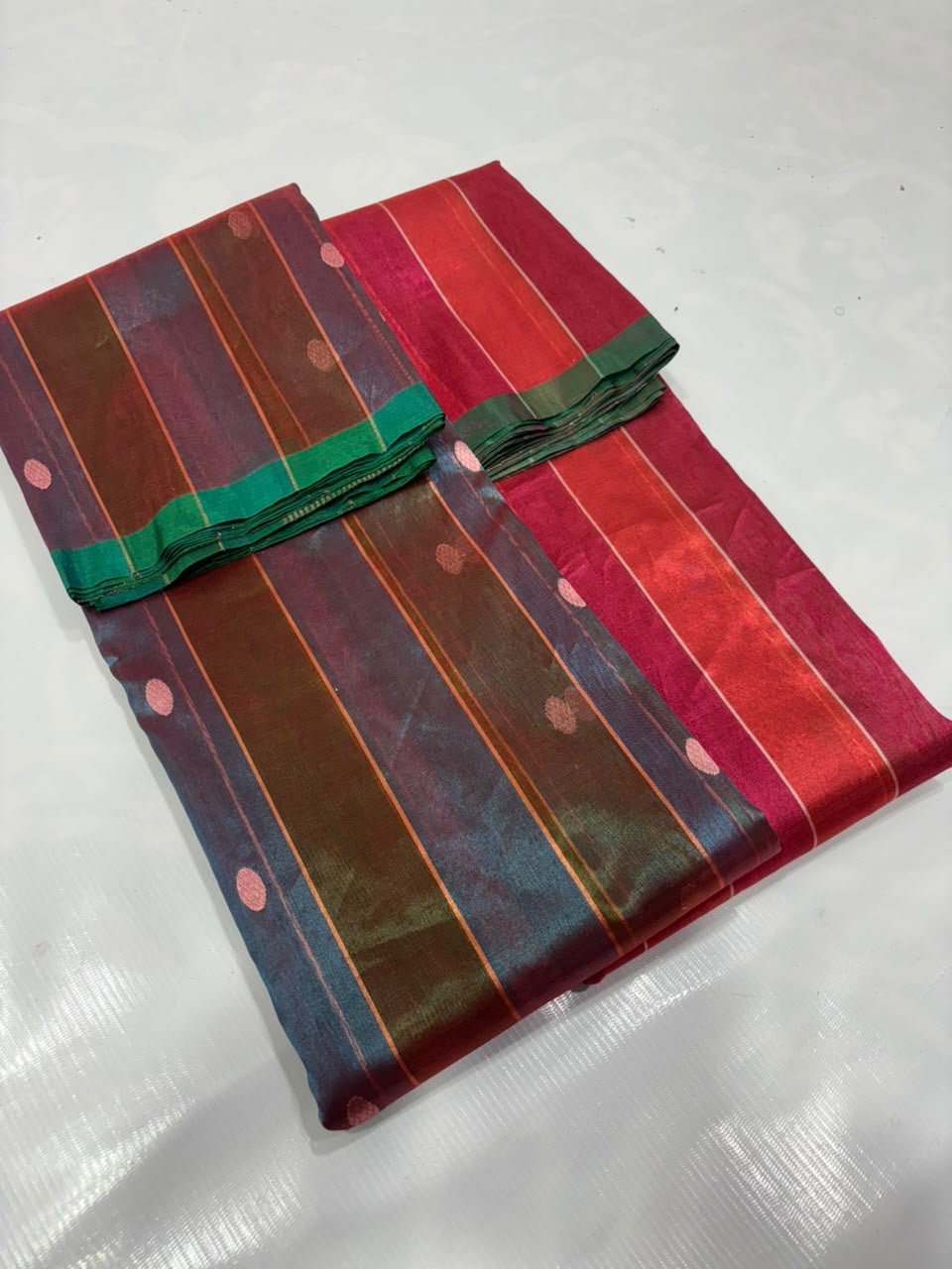 Close view of Vermilion Red Chanderi saree with Rani Pink sheen, fine jari lines and blue and green woven buttas