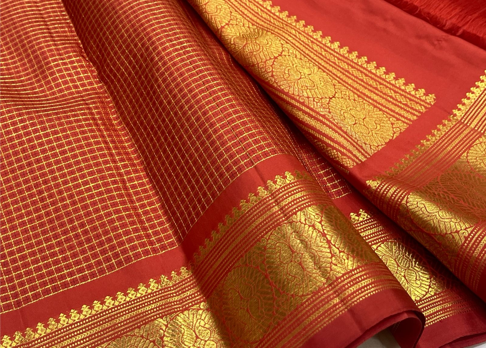 Close view of fine gold zari grid on Vermilion Red pure silk Kanchipuram saree.