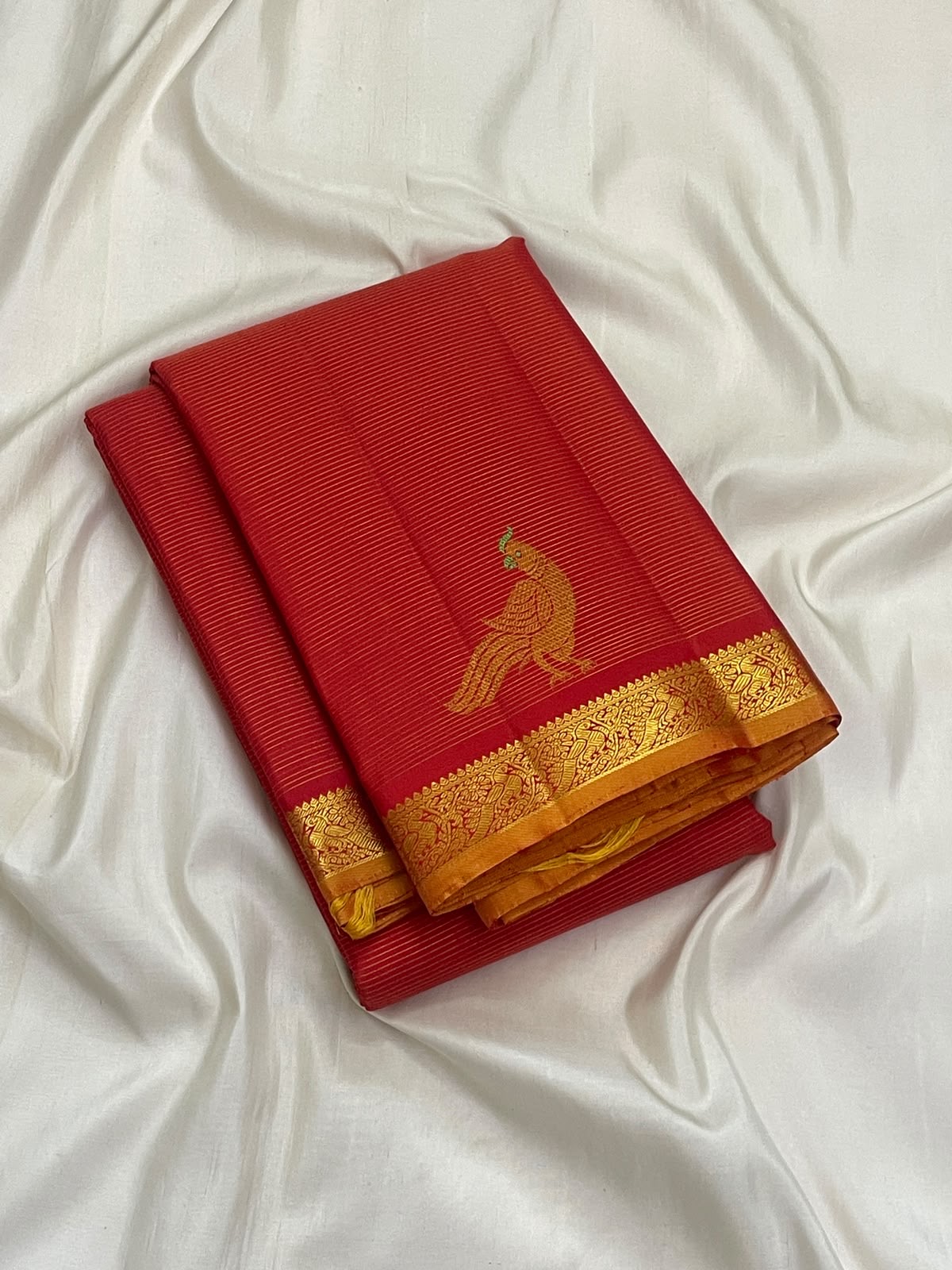 Vermilion red handwoven pure silk Vairaoosi saree with Mayil zari motif and gold border, folded view