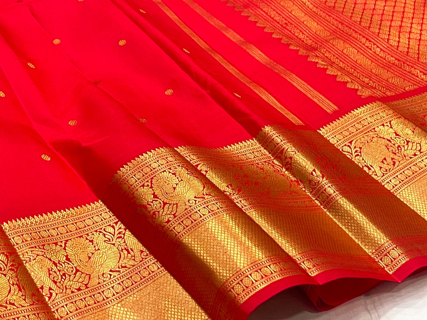 Vermilion Red KanchiPattu saree body close-up with gold zari buttas