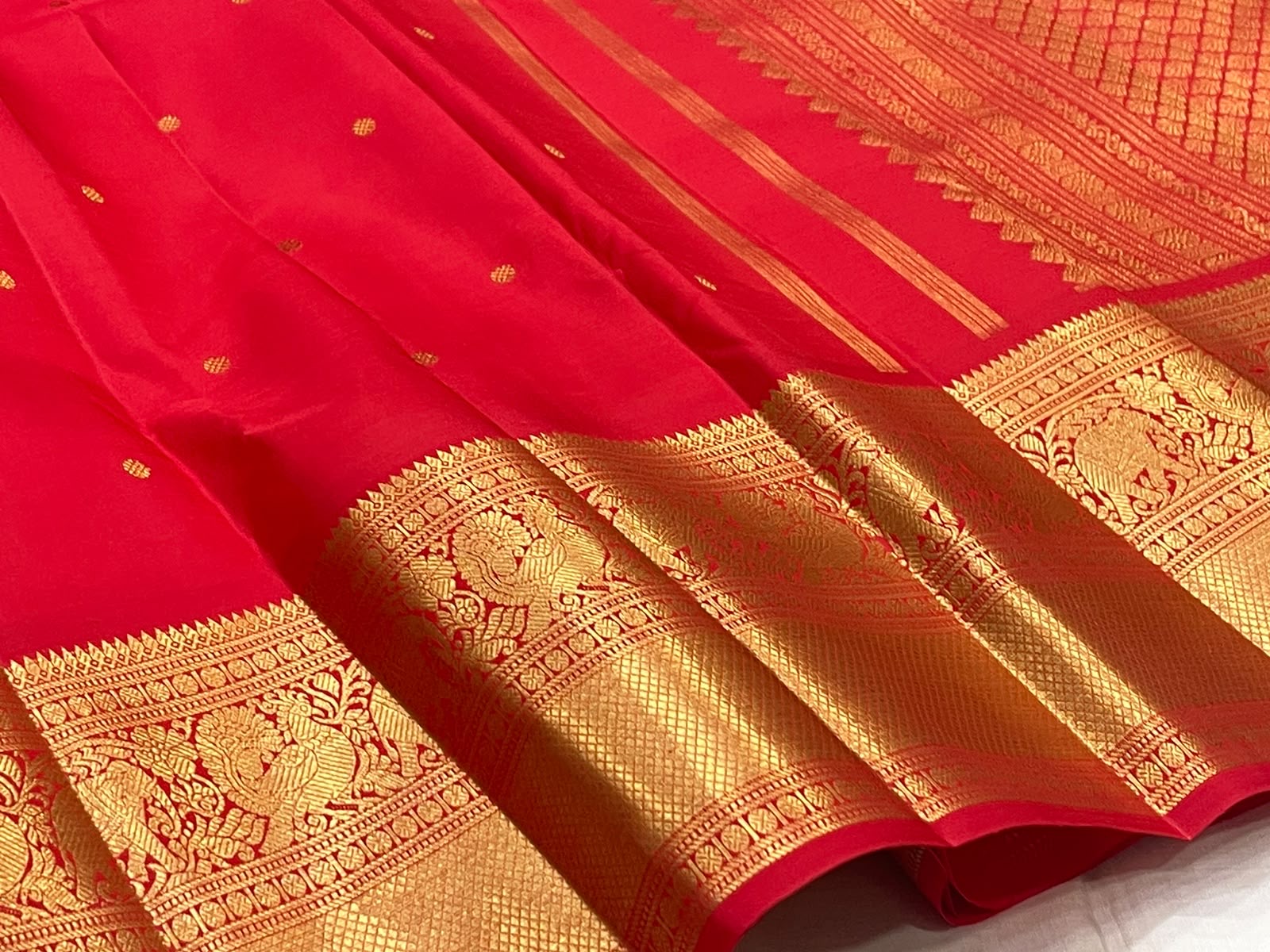 Vermilion Red KanchiPattu saree body close-up with gold zari buttas