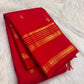 Vivid red Kanchipuram silk body with individually spaced classic-gold zari buttas across an open field.