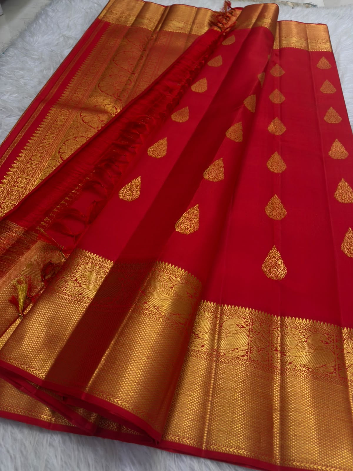 Vermillion red pure silk Kanchipuram Butta saree, with floral-drop zari buttas and broad gold border