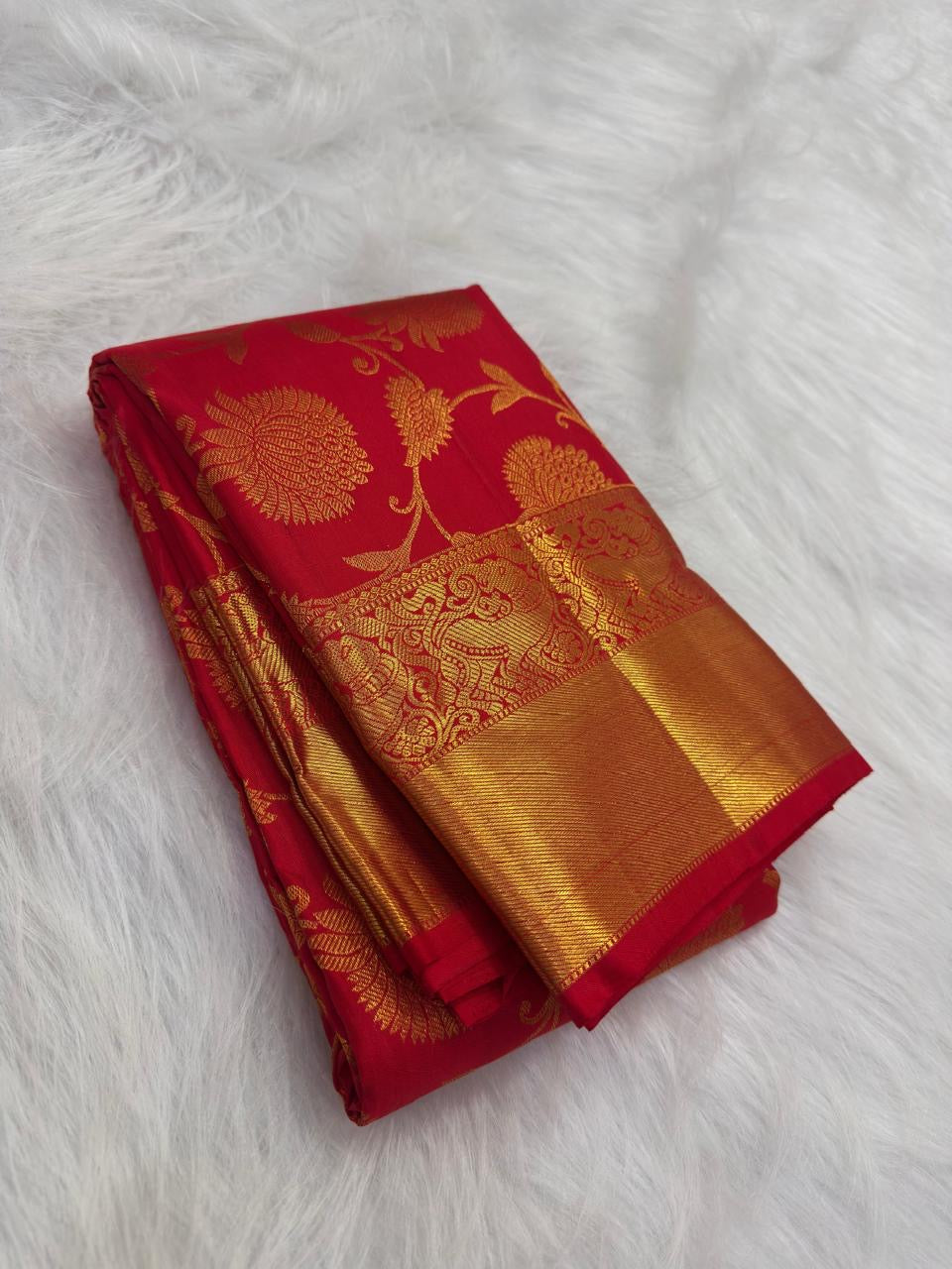Close-up of the gold zari floral jaal on a vermilion red silk saree