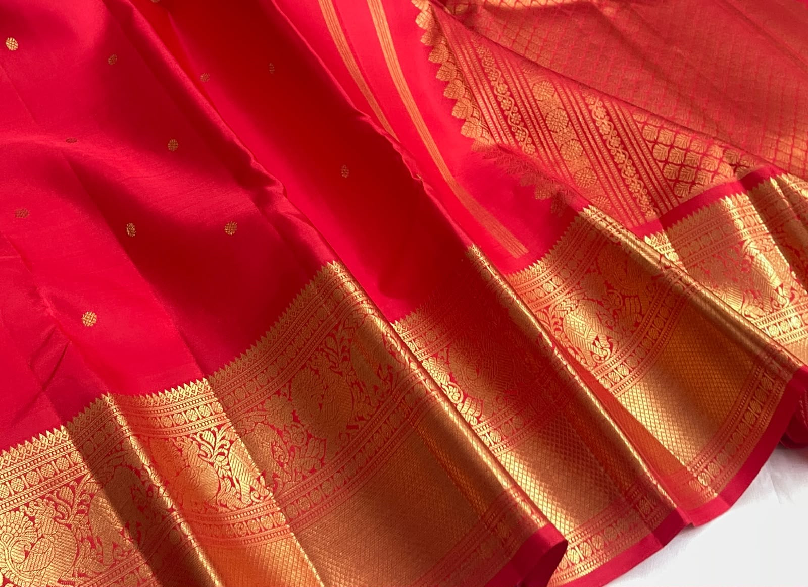 Vermilion Red handwoven Kanchipuram silk saree with small gold zari buttas and rich border.