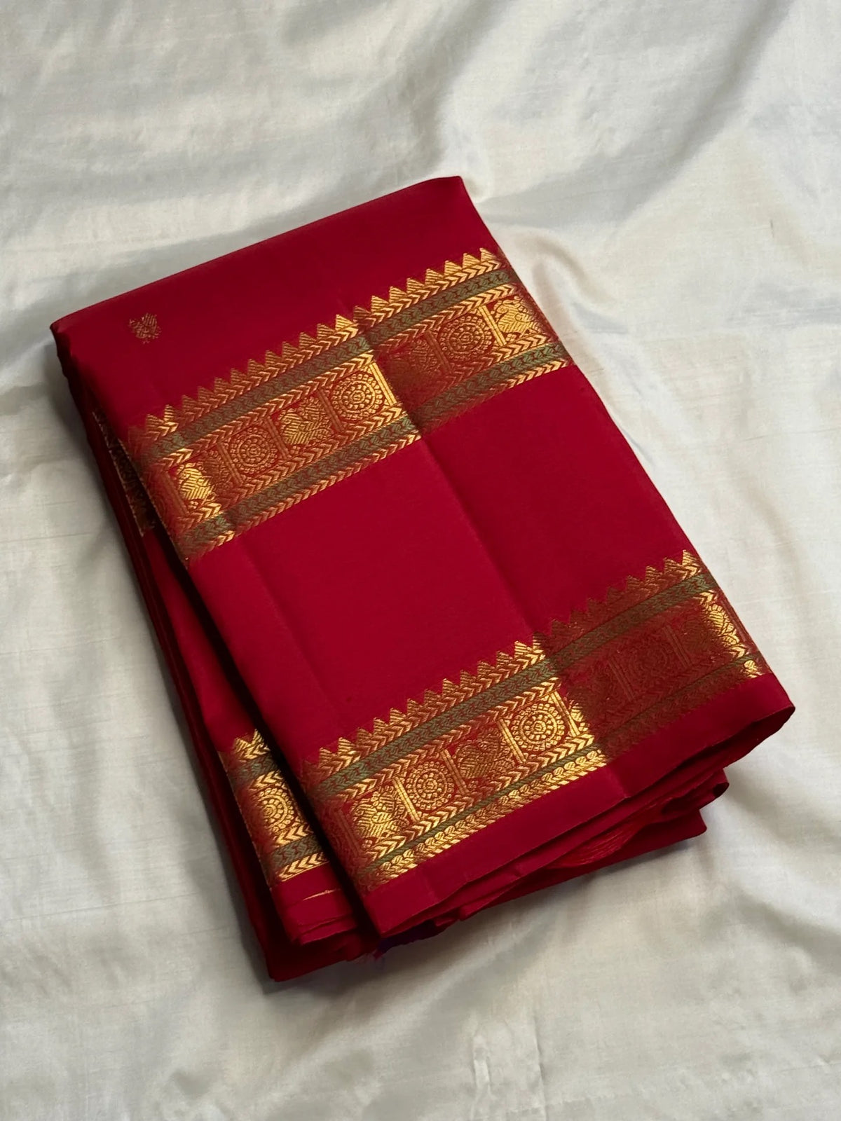 Red handwoven Kanchipuram silk saree with intricate parallel Rettapet gold zari borders.